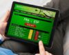 Man using sports betting app on tablet computer
