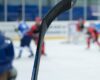 Close up of a hockey stick against a hockey game background