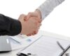 Handshake of business partners, when signing documents. Isolated on white background