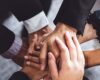 business people stacking hands together